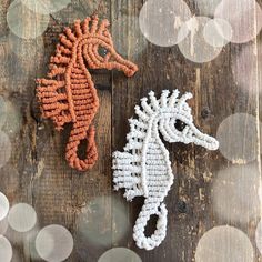 two knitted seahorses sitting on top of a wooden table next to each other