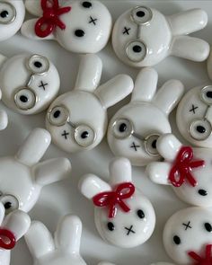 many white buttons with red bows and eyes are arranged in the shape of bunnies