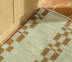 a brown and white rug sitting on top of a wooden floor next to a door