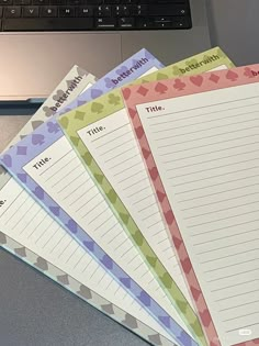 five lined notebooks sitting on top of a laptop computer next to an open keyboard