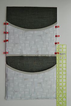 two pieces of fabric next to each other on a white surface with red pins in them