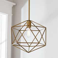 a light fixture hanging from the ceiling in a room with white walls and window sill