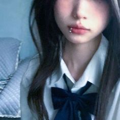 a girl with long hair wearing a white shirt and blue bow tie, posing for the camera