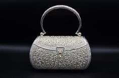 Incredible Solid Silver handbag hand embossed and pierced throughout. The bag has a silver handle and silver closure. It is marked and tested as silver. Exquisitely finished floral motif throughout. Each piece has been hand selected and meticulously identified and graded by a Graduate Gemologist who has been awarded a degree by the Gemological Institute of America (GIA). Please visit our Shop's About Page or our website for more information about our jewelry. If you have any questions about this Silver Handbags, Luxury Shoulder Bag With Silver-tone Hardware As Gift, Luxury Silver Shoulder Bag With Detachable Handle, Silver Rectangular Evening Bag For Reception, Luxury Formal Shoulder Bag With Silver Accents, Designer Silver Shoulder Bag With Detachable Handle, Luxury Shoulder Bag With Silver Accents For Formal Occasions, Elegant Ceremonial Handmade Bag, Silver Evening Bag With Detachable Handle For Wedding