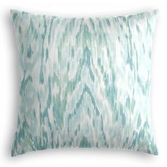 a green and white pillow with an abstract pattern on the front, sitting on a white background