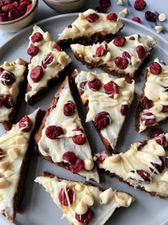 a white plate topped with slices of cake covered in frosting and raspberries