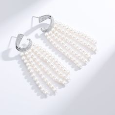 Transform your look with our Luxurious Curved Cubic Zirconia & Multi-Chain Pearl Earrings, a sophisticated blend of sparkle and elegance. The design features a gracefully curved band of brilliant cubic zirconia at the top, leading to five delicate chains adorned with lustrous 3-4mm freshwater pearls. Crafted meticulously in sterling silver, these earrings exude opulence and charm, making them a striking accessory for luxury events or whenever you desire to infuse a touch of glamour into your att Elegant Sparkling Hoop Earrings For Anniversary, Glamorous White Diamond Earrings, Classic White Chandelier Earrings For Party, Elegant Cubic Zirconia Hoop Earrings For Party, White Cubic Zirconia Evening Earrings, Elegant Sparkling Cubic Zirconia Hoop Earrings, Evening White Cubic Zirconia Earrings, White Elegant Earrings With Graceful Design, Graceful White Earrings With Elegant Design