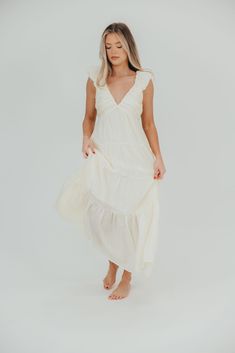 The Katy Midi has so many gorgeous details, it's easy to see why this is one of Worth Collective's new favorite summer dresses. Pictures don't do this beauty justice - from its pleated empire-waist bodice, to its ruffled cap sleeves and ultra-feminine tiered skirt, this dress speaks wildflowers and walks on the beach. Pair with neutral sandals for charming elegance. FIT: Runs true to size. MODEL: Model is 5’7” / wearing a small. MATERIAL: Self: 49% Rayon, 30% Nylon, 21% Tencel. GARMENT DETAILS: Sleeveless, lightweight summer dress in a midi length. Features a plunging V-neckline, with ruffled cap sleeves, pleated bodice, and stretchy, smocked back panel. Dress is constructed with an inverted empire waist, with a full, multi-tiered skirt. Partially lined. SIZE GUIDE: S (2-4) / M (6-8) / L ( Beach Dresses With Empire Waist And Ruched Details, Vacation Empire Waist Ruched Maxi Dress, Beach Empire Waist Ruched Maxi Dress, Empire Waist Maxi Dress For Brunch, Flowy Midi Dress With Pleated Bodice For Summer, Ruched Empire Waist Maxi Dress For Beach, Flowy Beach Dress With Pleated Bodice, Beach Maxi Dress With Ruched Empire Waist, Beach Maxi Dress With Empire Waist And Ruched Details