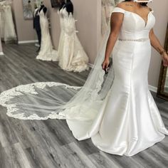 a woman in a wedding dress looking at herself in the mirror while she's getting ready to walk down the aisle