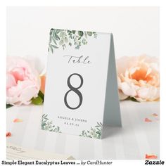 the table numbers are placed on top of each other with pink flowers in the background