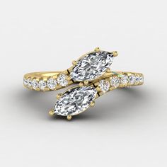 two pear shaped diamond engagement rings with side stones in yellow gold, set against a white background