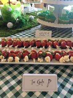 strawberries and bananas are arranged on a platter at a buffet table with green grass in the background