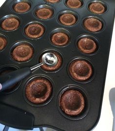 a person is using a spatula to stir cupcakes in a muffin pan