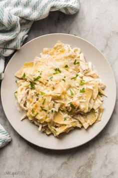 a white plate topped with pasta covered in cheese