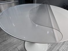 a white table with a curved glass top