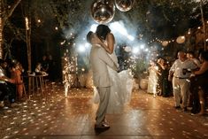 a bride and groom are dancing on the dance floor with sparklers in the air