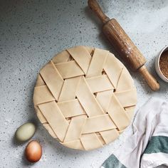 an uncooked pie sitting on top of a counter next to eggs