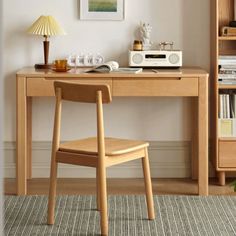 a desk with a chair, lamp and bookshelf in front of the wall