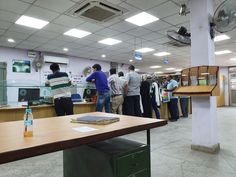 several people are standing in an office waiting for their jobs to be taken off the desks