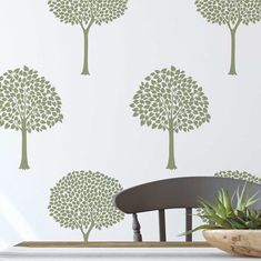 the wallpaper in this dining room is designed to look like trees with green leaves on them