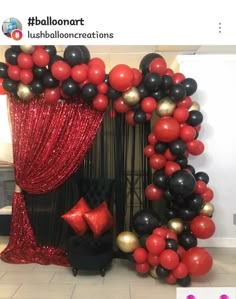 the balloon arch is decorated with red, black and gold balloons for an elegant party