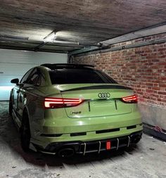 an audi car parked in a garage with brick walls and flooring on the ground