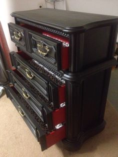 a black and red dresser sitting on top of a carpeted floor