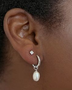 Classy and chic, we’re obsessed with the Willa ssilver Pearl Huggie Earrings in White Pearl—and you will be, too! A dainty cultured freshwater pearl dangles from a petite huggie for a lightweight style you’ll pair back with any stack. Metal Rhodium Over Brass Material White Pearl Closure Ear Post Size 1.8" Outside Diameter, 0.4"L X 0.3"W Charm Two Piercings Ear Aesthetic, Classy Silver Earrings, Silver Jewelry Aesthetic Earrings, Double Ear Piercing, Mission Fits, Minimalist Accessories Jewellery, Pearl Jewlery, Double Ear Piercings, Classy Earrings