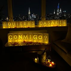 candles lit up in the shape of letters that spell out'conmigo?