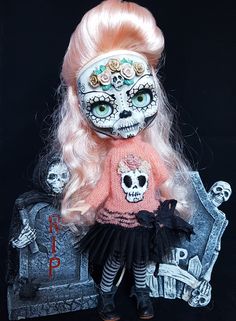 a doll with pink hair and skull makeup sitting on a bench in front of a black background