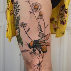 a woman's thigh with flowers and a bee on it