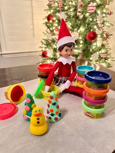 an elf is sitting on the table with toys