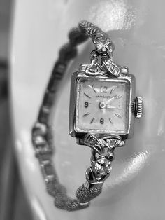 Vintage Art Deco 14k White Gold Hamilton Watch with genuine diamond accents. The watch is 14k gold with diamonds.  There are two larger round brilliant diamonds that measure 3.5mm in diameter and four smaller diamonds that are 1.5mm in diameter.  Total carat weight of the diamonds is approximately 0.42 calculated by measurements.  They are round brilliant cut and nice quality in the range of SI1 clarity and H/I color.   The watch face and bezel are solid 14k white gold and stamped.  The band is Classic Diamond Accented Watch For Anniversary, Formal Yellow Gold Diamond Watch With Diamond Accents, Formal Yellow Gold Diamond Watch With Accents, Classic Diamond Jewelry With Brilliant Cut, Classic Silver Diamond Watch With Cubic Zirconia, Yellow Gold Diamond Watch With Brilliant Cut For Anniversary, Classic Diamond White Watch For Anniversary, Classic Jewelry And Watches With Diamond Accents For Anniversary, Classic Cubic Zirconia Diamond Watch