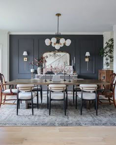 a dining room table with chairs and a mirror on the wall