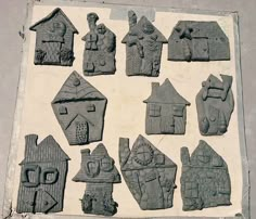 an assortment of carved clay houses on display