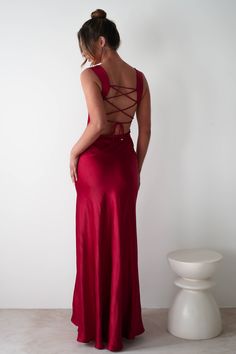 This gown is your perfect choice for debs, prom or any formal event. A look that blends classic glamour with contemporary style. Designed for timeless allure and effortless sophistication. Featuring a graceful cowl neckline and thick shoulder straps, this dress offers a flattering, structured fit. The sultry thigh-high slit adds a bold, modern touch, while the luxurious satin fabric drapes beautifully to enhance your silhouette. Highlights Stunning red gown with cowl neckline Soft satin material Valentines Formal Dresses, Wine Red Maxi Dress, Uk Formal Dresses, Red Revenge Dress, Satin Dresses With Lace-up Low Back, Burgundy Dresses Formal, Red Maxi Dress Formal, Fitted Tie Back Slip Dress For Prom, Fitted Slip Dress With Tie Back For Prom