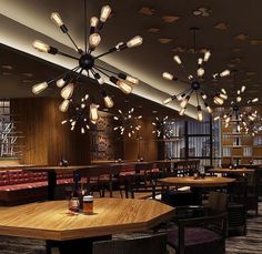 a restaurant with wooden tables and chairs, lights hanging from the ceiling over it's bar area