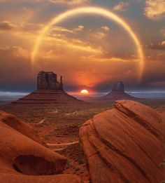 the sun is setting over monument buttes in monument national park, utah as seen from an alien landscape