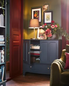 a living room filled with furniture and flowers on top of a book shelf in front of a doorway