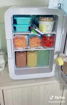 an open refrigerator filled with lots of food and containers on top of the fridge door