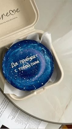 a blue frisbee in a white box with writing on it