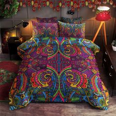 a colorful bed with an intricately designed comforter and matching pillow cases on it