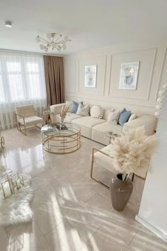 a living room filled with white furniture and lots of windows