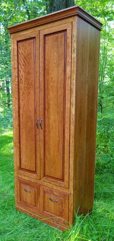 a wooden armoire sitting in the grass