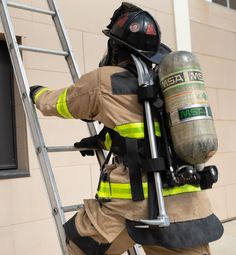 a fireman climbing up a ladder with his helmet on