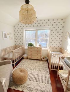 a baby's room with two cribs and a rug on the floor