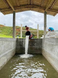 two people are standing on the edge of a water source