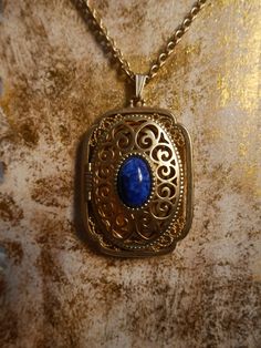 This stunning gold plated locket features a cobalt blue stone in the center and can fit 2 photos inside. It is in excellent condition. Measurements- Bail to end of pendant: 2.5 inches Width: 1.5 inches Chain: 14 inches *ALL ITEMS ARE FINAL SALE AND COME FROM A SMOKE FREE HOME. ITEMS MAY HAVE SCUFFS, ODOR STAINS/MARKS OR HOLES. I DO NOT INSPECT ANY ITEMS SOLD UNLESS INDICATED IN PHOTOS OR DESCRIPTION. ALL ITEMS ARE PURCHASED AS IS AND ARE SOLD AS IS.* Blue Hallmarked Medallion Jewelry, Blue Brass Jewelry With Vintage Charm, Formal Blue Locket Jewelry, Antique Blue Jewelry With Large Pendant, Blue Brass Necklace With Vintage Charm, Antique Blue Oval Pendant Jewelry, Antique Blue Brass Jewelry, Blue Oval Locket Necklace, Oval Blue Locket Necklace