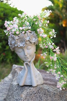 a vase with flowers in it sitting on top of a rock