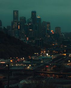 the city skyline is lit up at night, with many lights on and buildings in the background